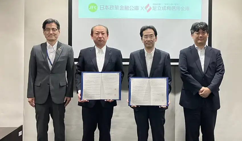 覚書を手にする土屋理事長（左から2人目）と日本公庫の奥平英裕千住支店長（同3人目）ら（9月5日、同信金本部）