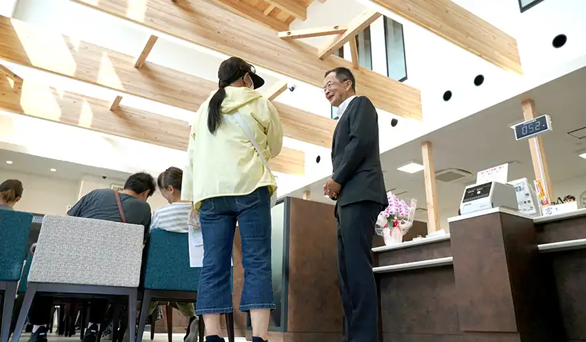 1階ロビーで来店客をもてなす井上勝彦専務理事（右、9月8日、足立支店）