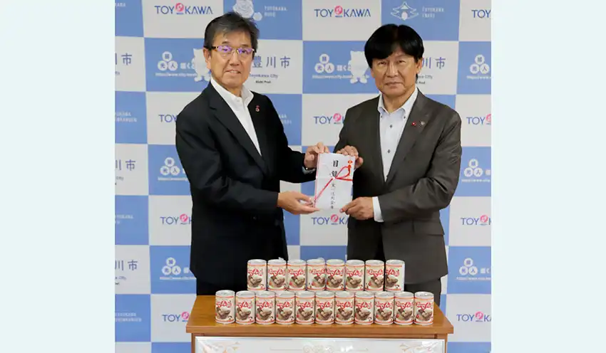 豊川市の竹本幸夫市長（右）に防災用缶詰の目録を手渡した真田理事長（9月10日、豊川市役所、同信金提供）
