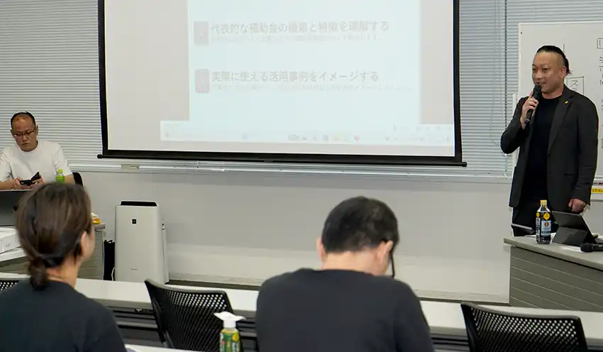 カレーグランプリ出店者に補助金を紹介する伊窪氏（9月17日、興産信金本部）
