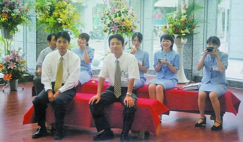新本店がオープンした際に撮影。本店営業部渉外担当時の石沢氏（中央、2003年7月、本人提供）