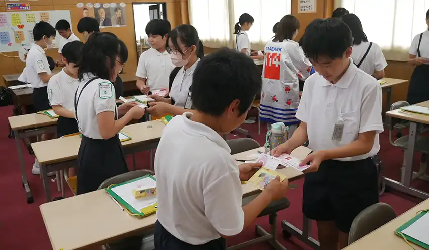百十四銀のブースで名刺交換に挑戦する児童たち（9月16日、大元小学校）