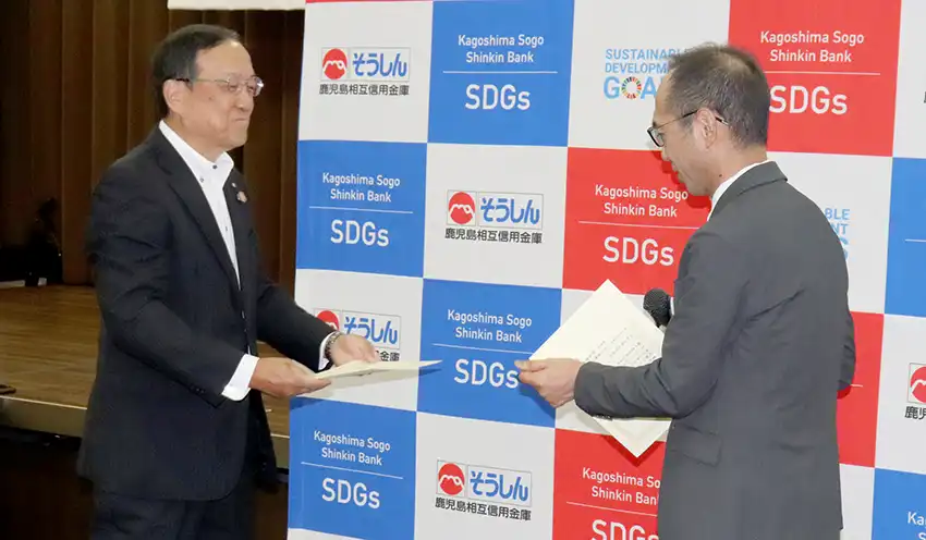 寄付金贈呈式で感謝状を受け取る永倉理事長（左、9月4日、本部）