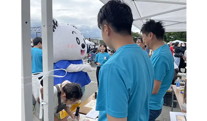 紙幣鑑定の体験機会を提供する山梨中央銀の若手行員（9月23日、富士山駅前、山梨中央銀提供）
