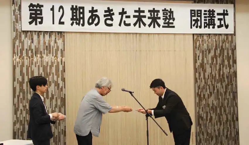 関教授（中央）から卒業証を受け取る塾生（右、9月3日、秋田銀提供）