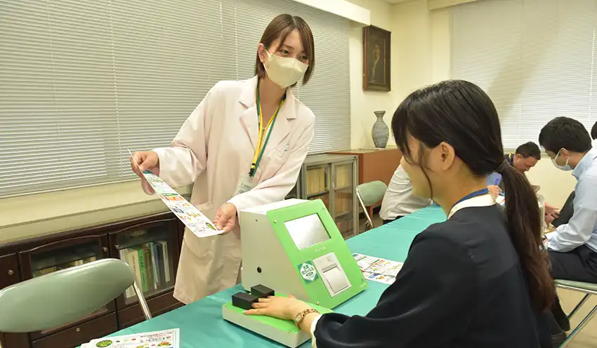 専用の機械で野菜摂取量を測定する職員（9月4日、本店）