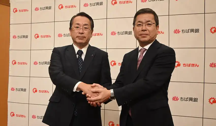 会見後握手する米本頭取（左）と梅田頭取（9月29日、千葉市内のホテル）