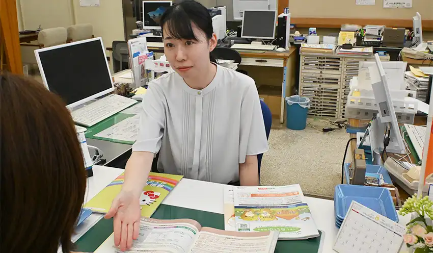 ローカウンターで保険商品を説明する赤平日美葵さん（8月8日、根城支店）