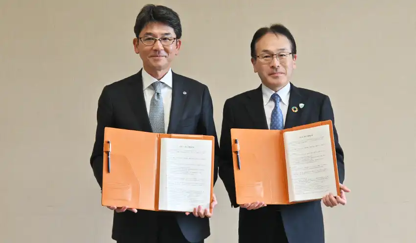 協定書を持つ岩山頭取（右）と川村公司・岩手日報社社長（9月24日、岩手日報社）