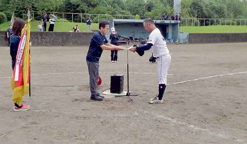 表彰状を贈る近藤会長(中央、9月20日、高鍋町小丸河畔球場、宮崎県信金協会提供)