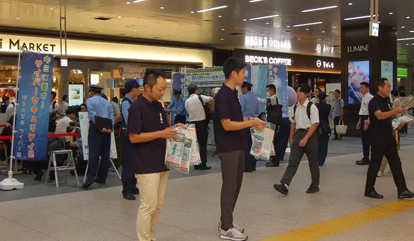 道徳銀行と書かれた揃いのポロシャツ姿で防犯を呼びかける行員（9月10日、JR大宮駅）