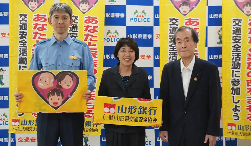 贈呈式で(左から)山形県警察本部の水庭誠一郎本部長、山形県交通安全協会の佐藤光子会長、長谷川相談役(9月19日、山形県警察本部)
