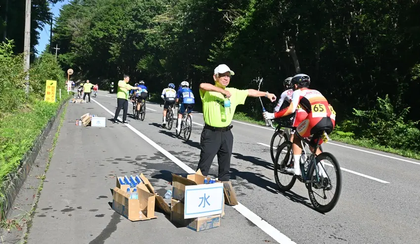選手に水を手渡す太田理事長(左、9月7日、葛尾村)