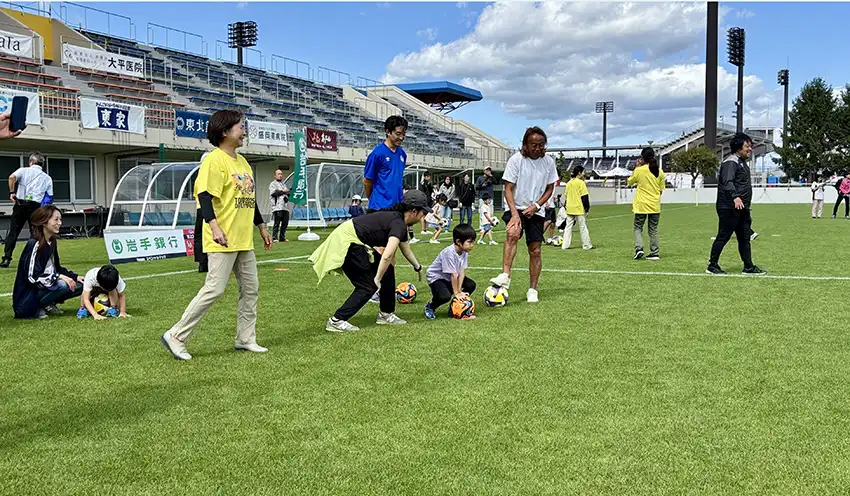 北澤氏からサッカーの指導を受ける子供（9月21日、いわぎんスタジアム、岩手銀提供）