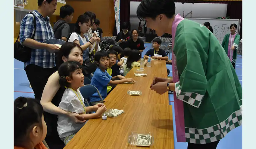 子どもと交流する信金職員（右、9月15日、山陽高校体育館）