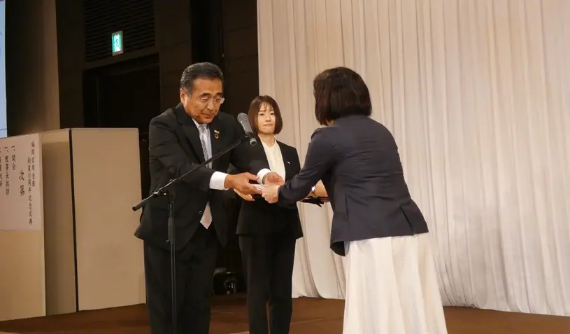 福岡市社会福祉協議会へ記念品を贈呈する野見山理事長(9月6日、ソラリア西鉄ホテル福岡)