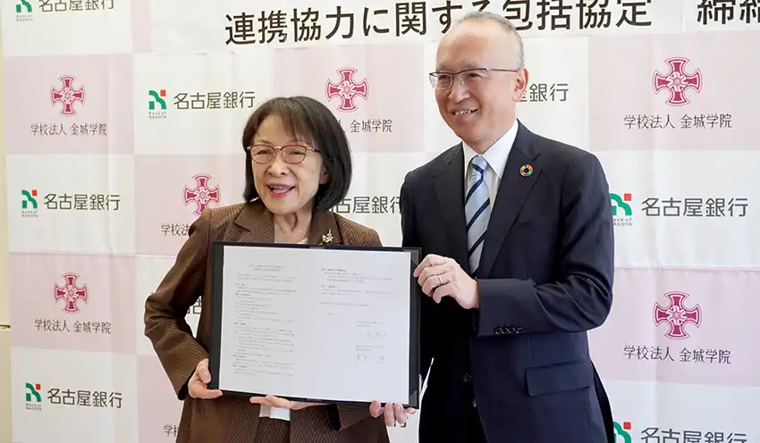 協定書を手にする藤原頭取（右）と小室理事長（10月20日、名古屋市内）