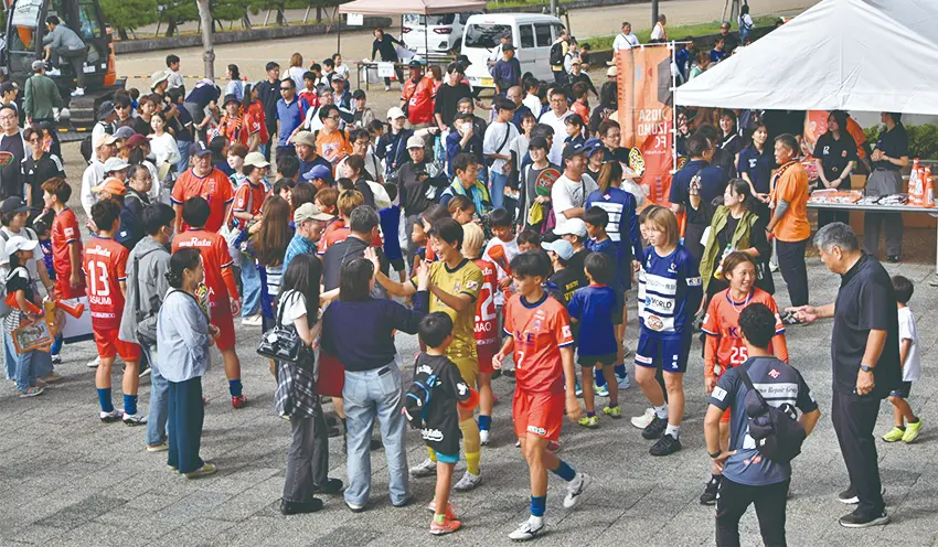 島根銀サポーティングマッチの勝利をファンと喜び合うディオッサ出雲FCの選手（10月5日、浜山公園陸上競技場）