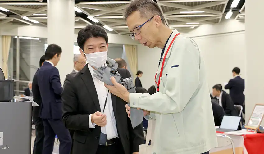製品の説明を聞く参加者(右、10月24日、横浜市金沢産業振興センター)