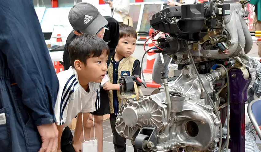 自動車整備を体験する小学生ら(10月25日、新市街アーケード、熊本信金提供)