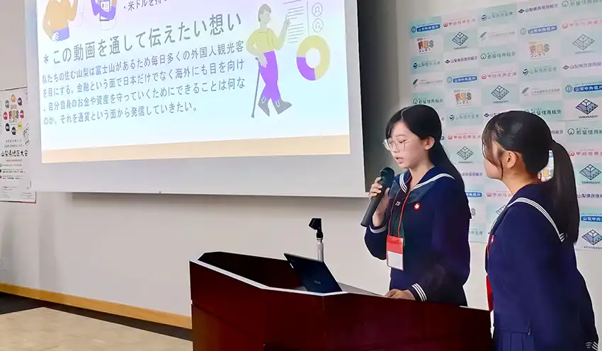 金融機関アライアンス賞に選ばれた動画を説明する都留高生(10月26日、山梨大学、日本金融教育支援機構提供)