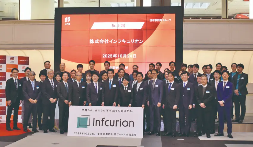 社員や関係者と記念撮影。ゲストでCCIグループの杖村修司社長(前列右から3人目)が駆け付けた(10月24日、東証)