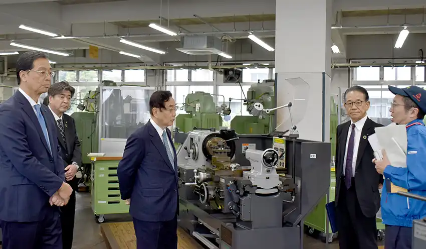 ポリテクセンターの担当者から訓練施設の説明を受ける千葉県内信金の理事長ら(10月31日、同センター)