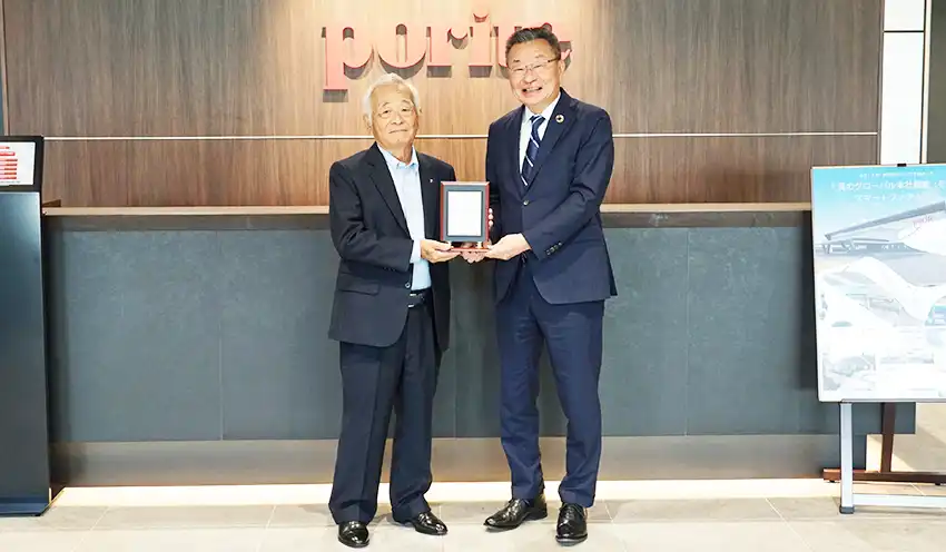 PIFの記念盾を手にするポーライトの菊池眞紀会長（左）と池田会長（10月10日、ポーライト本社）