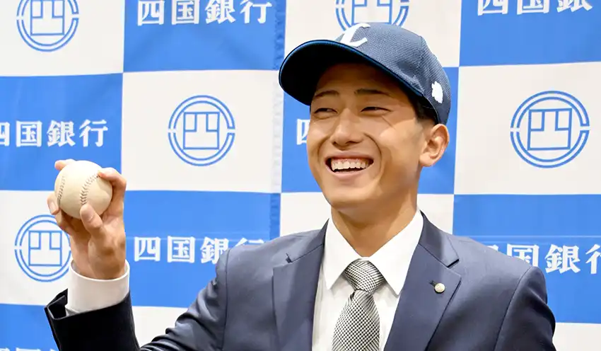 埼玉西武ライオンズの帽子をかぶり笑顔でポーズをとる川田選手（10月23日、本店、四国銀提供）