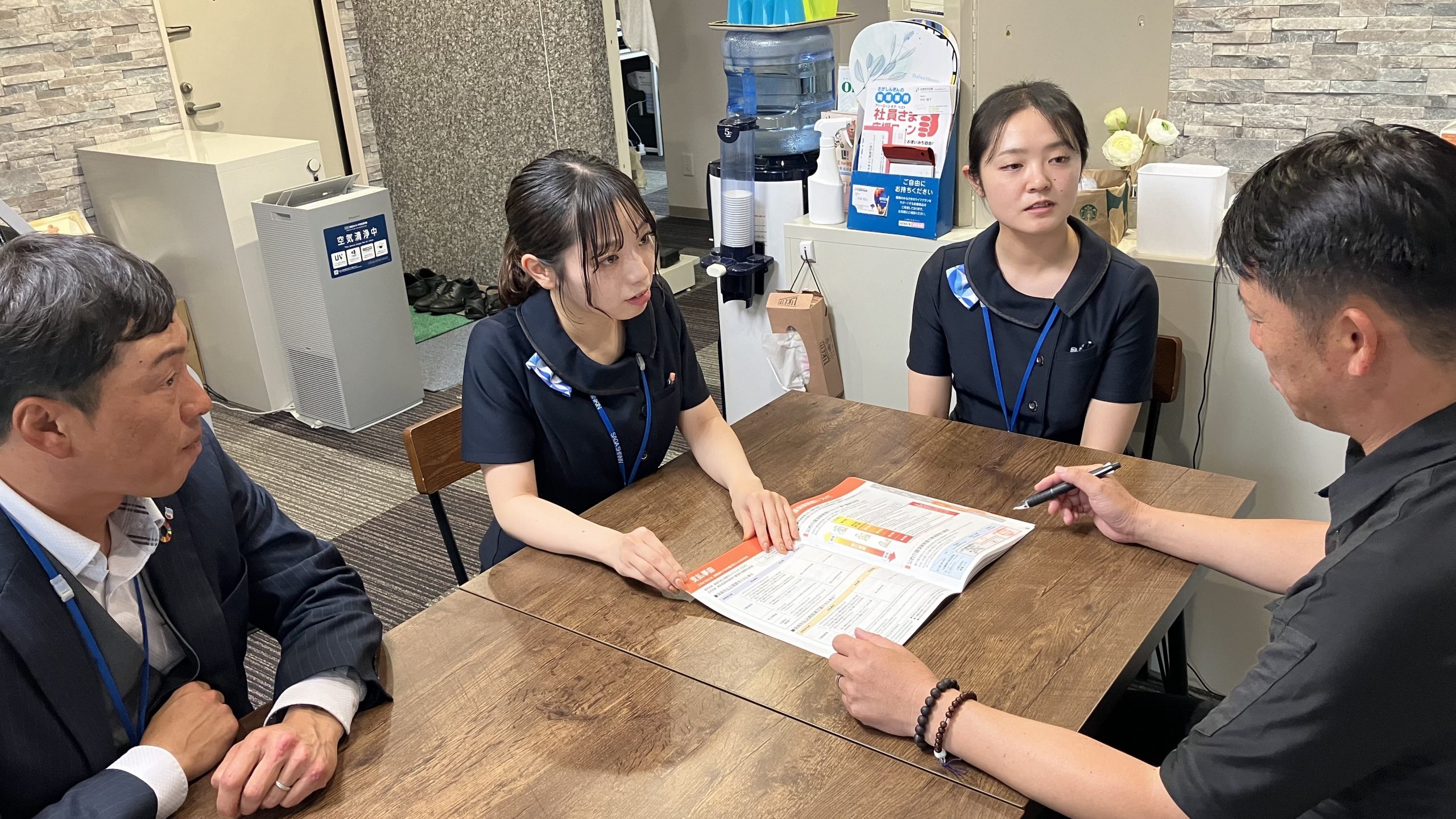 鳥栖設備工業の齊藤慎也専務(右)に保険商品を案内する(左から)古賀支店長代理、田中さん、川口さん(9月25日、鳥栖市)