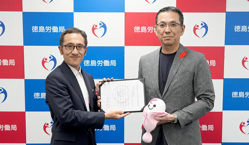 認定通知書を持つ亀井崇・徳島労働局長（左）と山下真弘・阿波銀専務（10月2日、徳島労働局、阿波銀提供）