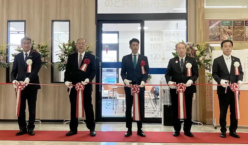 テープカットに臨む鰀目理事長（左端）、鈴木正俊会長（左から4人目）、畠中支店長（右端、10月6日、富来支店）
