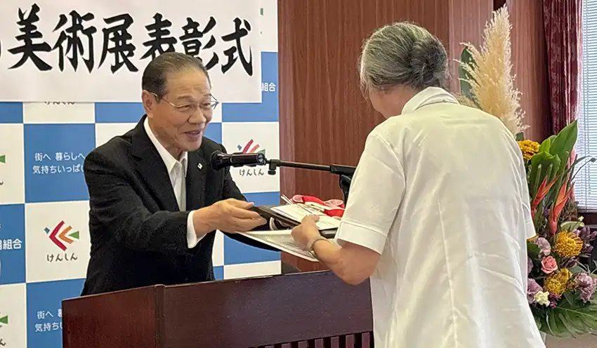 三野さん（右）に表彰盾を手渡す𠮷野理事長（10月8日、本店）