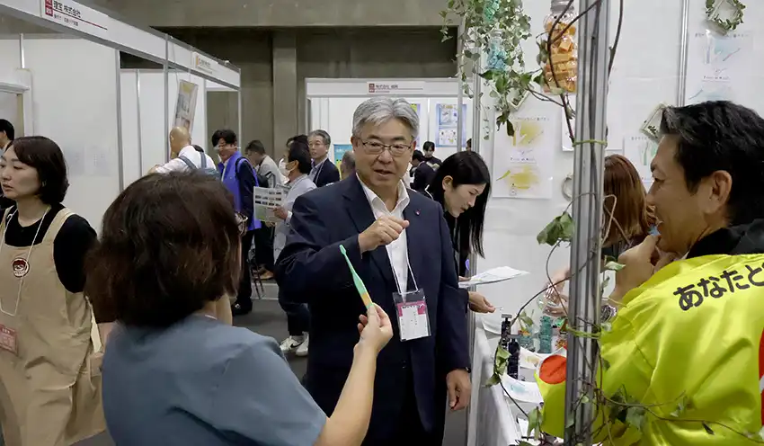 出展者から商品説明を受ける東春信金の神理事長（左から３人目、10月10日、ポートメッセなごや）