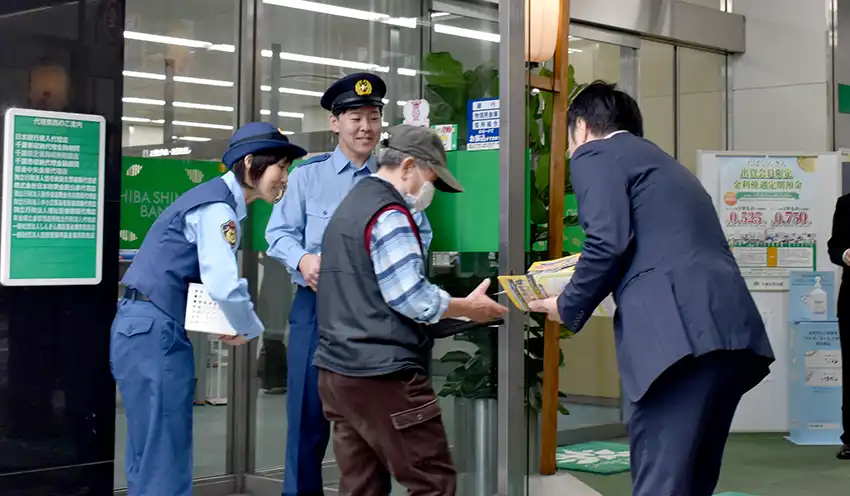 詐欺防止のチラシやポケットティッシュを配布する職員や警察官ら（10月15日、千葉信金本店）