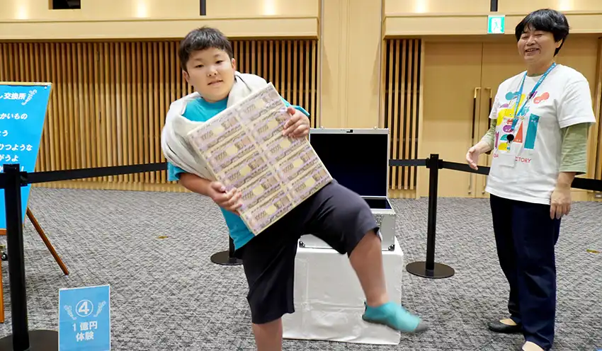 1億円の重さを体感する小学生(10月17日、半田市)