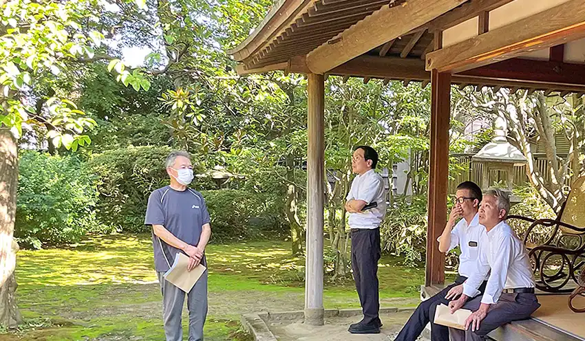 旧風間家住宅丙申堂で地元ガイド（左）の説明を聞く（左2人目から）田尾・荘内銀取締役、エイチ・アイ・エスの山野辺淳取締役・HIS JAPAN Presidentと加治木宏・法人営業本部長（8月18日、荘内銀提供）