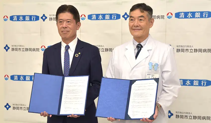 協定書を交わす岩山頭取（左）と小野寺理事長（10月8日、静岡市立静岡病院）