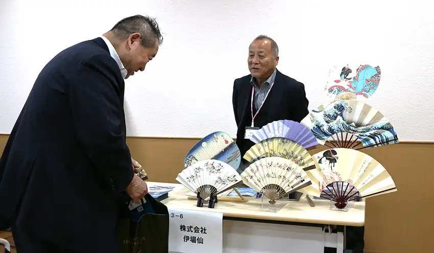 自社で製作した扇子やうちわを紹介する伊場仙の担当者(10月21日、日本橋プラザ)