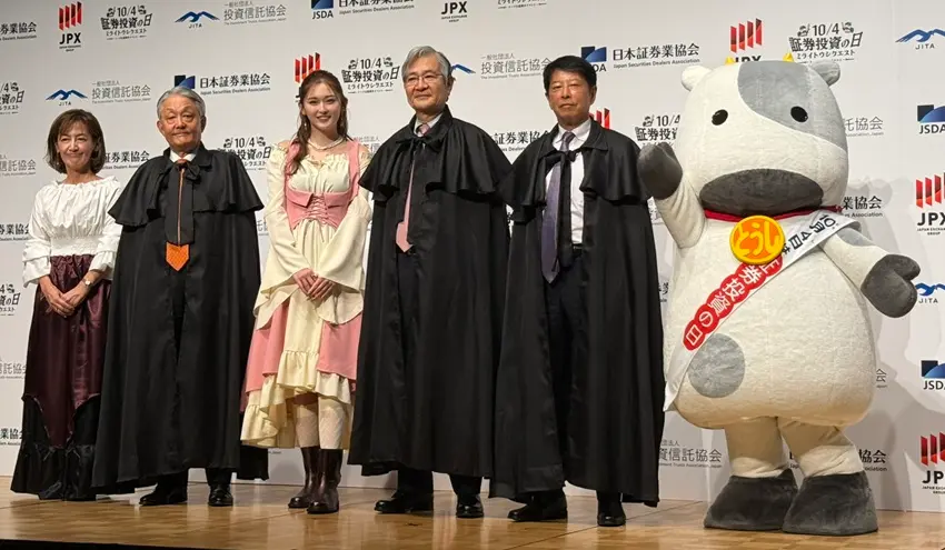 「ミライトウシクエスト」で登壇した（左から）村松さん、JPXの山道グループCEO、ゆうちゃみさん、日証協の日比野会長、投信協の松下会長、日証協のマスコット「とうしくん」（10月4日、KABUTO ONE）