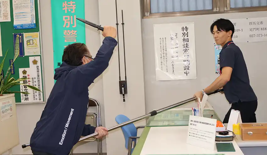 さすまたで強盗犯の侵入を抑える職員（10月16日、高崎信金群馬町支店）