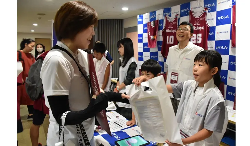 来場者へ景品を手渡す小学生（10月18日、とどろきアリーナ）