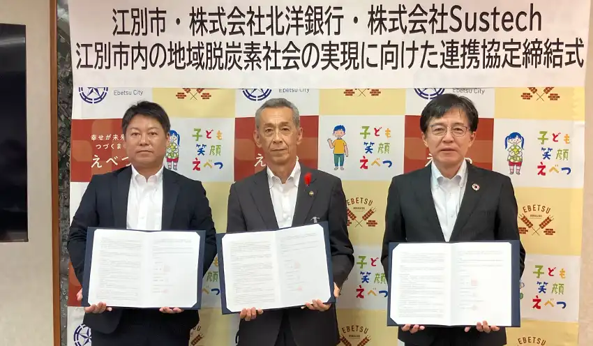協定書を持つ（左から）サステックの飯田社長、江別市の後藤市長、北洋銀の米田常務取締役（10月22日、江別市役所）
