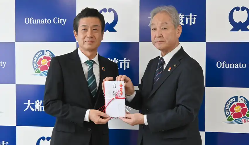 募金の目録を手に持つ長瀬執行役員地域貢献部長（左）と渕上市長（10月17日、大船渡市役所）