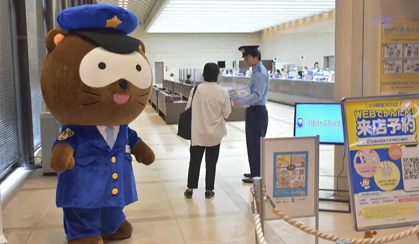 ATMコーナーで来店客に啓発チラシを手渡す警察官（滋賀銀提供）