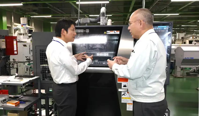 安田支店長（左）にＮＣ旋盤の仕組みを説明する正木社長（10月９日、正木製作所）