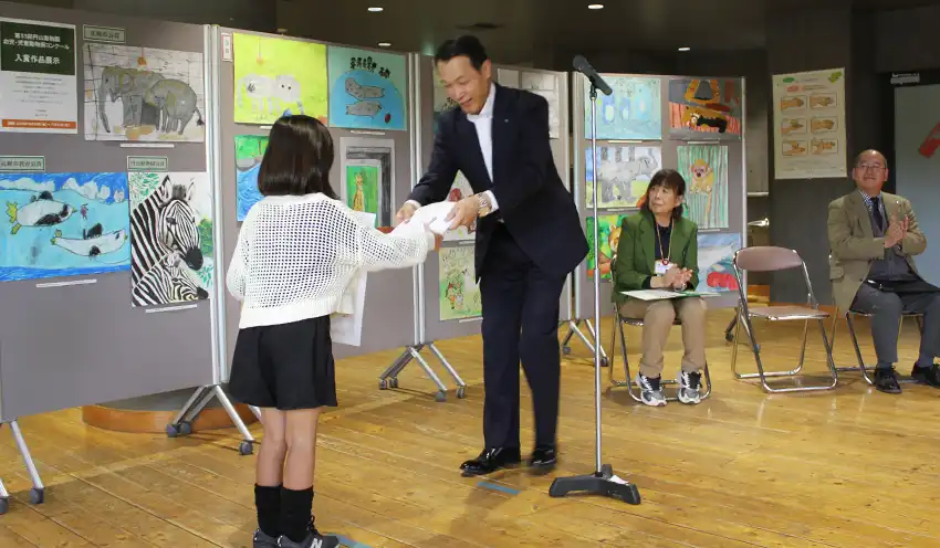 受賞者に賞状と記念品を手渡す佐藤理事長(10月26日、札幌市円山動物園キリン館)