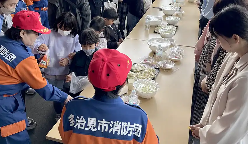 防災クッキングを提供した消防団（11月1日、同信金提供）