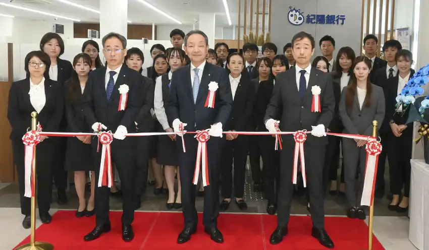 泉ヶ丘支店の行員を前にテープカットする（前列左から）中嶋崇裕執行役員・堺事業部長、原口頭取、川西支店長（11月4日、泉ヶ丘支店）