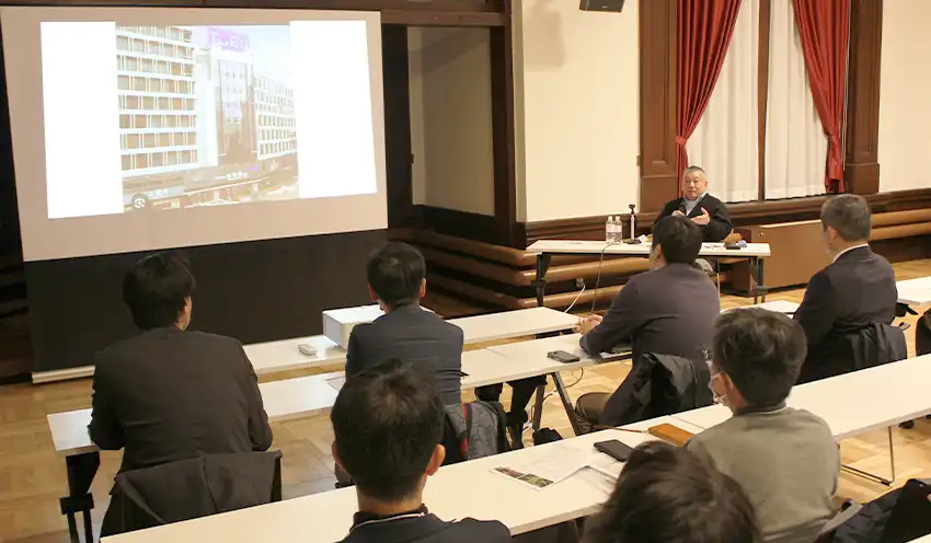 講演する内田氏（右奥、11月3日、北海道庁旧本庁舎赤れんが庁舎ホール）